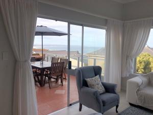 a living room with a chair and a table with an umbrella at Boggoms' View in Boggomsbaai