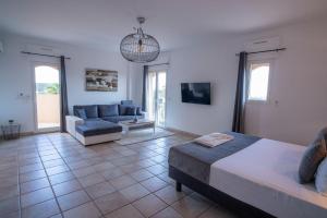 ein Wohnzimmer mit einem Bett und einem Sofa in der Unterkunft Villa Riposa in Fréjus
