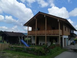 a house with a deck and a playground at Ferienwohnungen Dopplerhof in Piding