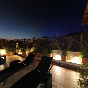 a patio with chairs and potted plants at night at Hotel Adria in Bari