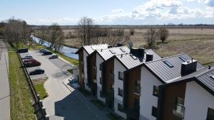 z góry widok na budynek z drogą i samochodami w obiekcie M&K Apartament Magiczny Las, Gdańsk - Wyspa Sobieszewska w Gdańsku