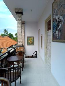 una casa con balcón con mesas y sillas en Roy Guest House, en Canggu