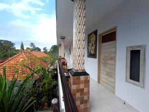 Un balcón de una casa con un pilar en Roy Guest House, en Canggu 9 fotos más