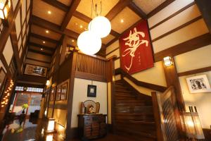 un bâtiment avec un escalier et un panneau sur le mur dans l'établissement 野沢温泉　奈良屋旅館, à Nozawa Onsen