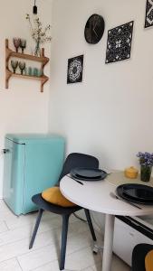 a dining room with a table and a blue refrigerator at Vintage Anna Apartment in Kuldīga