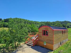 eine kleine Hütte mit einer Treppe neben einem Baum in der Unterkunft La roulotte du tonnelier in Castelnau-de-Montmiral