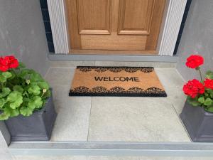 a welcome mat in front of a door with flowers at Willshaw Suites for families over 25 only in Blackpool