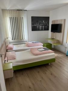 a bedroom with two beds and a television in it at Waffel Cafe HOSTEL Monteurwohnung Ferienwohnung in Kassel