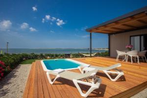 a wooden deck with chairs and a swimming pool at Arena Grand Kazela Camping Homes in Medulin