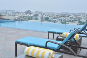 a swimming pool with a chair and a table on a roof at Cygnett Park BL in Jaipur