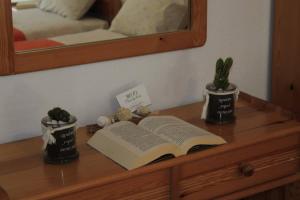 an open book on a wooden table with a mirror at Dioni Lux inn 2 in Pachaina