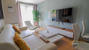 123home - Suite & spa XL في مونتِفري: غرفة معيشة مع أريكة بيضاء وطاولة