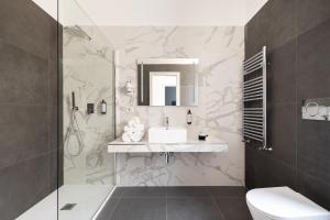 a bathroom with a sink and a toilet and a shower at DA ME Suites in Rome