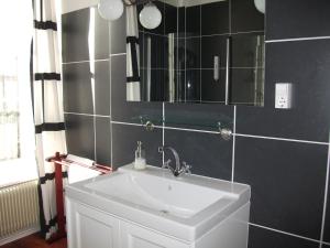 a bathroom with a white sink and a mirror at La Mirabelle in Cornimont +15 photos