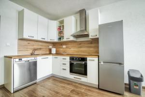una cocina con armarios blancos y electrodomésticos de acero inoxidable en Apartment Marina with sea view, en Pula