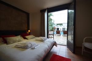 een slaapkamer met een groot bed en handdoeken bij Hotel Tropical in Durbuy