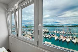 ein Fenster mit Blick auf einen Yachthafen mit Booten in der Unterkunft Apartment Marina with sea view in Pula