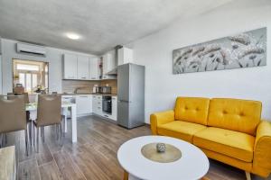 a living room with a yellow couch and a table at Apartment Marina with sea view in Pula