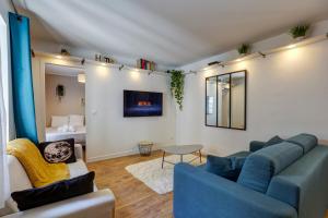 un soggiorno con divano blu e tavolo di Le Paquier - MyCosyApart, Vieille ville, Calme, Lac 100m, Netflix ad Annecy