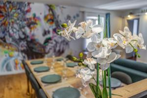 un tavolo con piatti verdi e un vaso con fiori bianchi di Le Paquier - MyCosyApart, Vieille ville, Calme, Lac 100m, Netflix ad Annecy