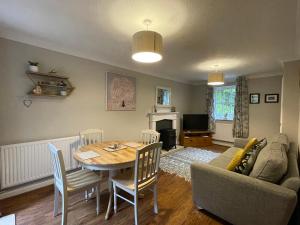 een woonkamer met een tafel en een bank bij Drake Cottage - riverside retreat, Jackfield, Ironbridge Gorge, Shropshire in Coalport