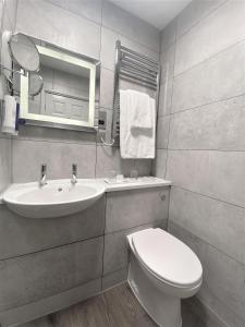 a bathroom with a toilet and a sink and a mirror at Best Western Premier EMA Yew Lodge Hotel in Castle Donington