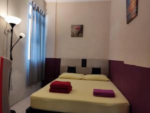 um quarto com uma cama com duas toalhas vermelhas em Penang Tanjung Bungah Medium Cost Apartment Stay em Tanjung Bungah