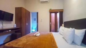 a hotel room with a bed with two towels on it at Andewi Homestay RedPartner - Minimum Stay 30 Nights in Pesanggaran +5 photos