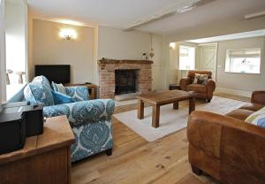 a living room with a couch and a fireplace at The Cottages - Sherwood Forest in Edwinstowe