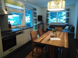 a kitchen with a wooden table and a dining room at Alpenchalet Breitspitz in Partenen