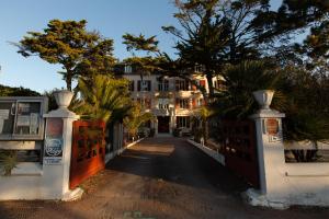 una casa con un cancello e alberi su una strada di Hôtel de la Plage, Ronce-les-bains, La Tremblade a Ronce-les-Bains