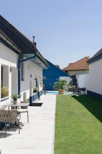 un patio con mesas y bancos en un edificio en KRACHER Landhaus No. 2 en Illmitz