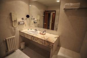 un bagno con lavandino e specchio di Hotel Roc Del Castell a Canillo