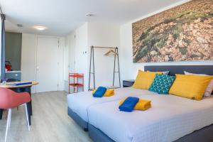 a bedroom with two beds with yellow and blue pillows at Roosjesweg 2 Luxe gastenkamer 400 meter van strand met parkeerplaats in Domburg