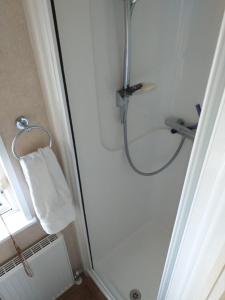 a bathroom with a shower with a white towel at 6 BERTH DELUXE ML7 ON THE GOLDEN PALM in Chapel Saint Leonards