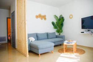 - un salon avec un canapé bleu et une table dans l'établissement SARMENT EXOTIQUE, à Châlons-en-Champagne