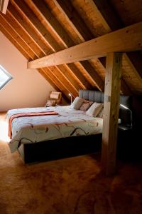 a bed in a attic with a wooden ceiling at All Senses Ferienwohnung in Hirschbach