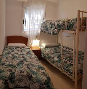 a bedroom with two bunk beds and a window at Marina dor Frontal 1ª línea in Oropesa del Mar