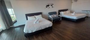 two beds in a room with wood floors at SY Staycation - Apartment in Bayan Lepas