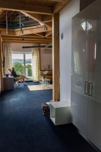 a living room with a person sitting on a couch at All Senses Ferienwohnung in Hirschbach