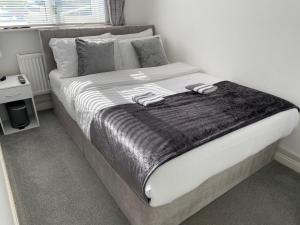 a bed with a blanket on it in a bedroom at Stony Apartment House in Doncaster