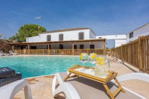 a pool with a table and two glasses of wine at Casa Rural San Miguel in Morón de la Frontera