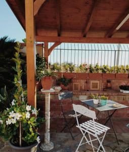 eine Terrasse mit einem Tisch, Stühlen und Topfpflanzen in der Unterkunft Silarus B&B in Capaccio-Paestum
