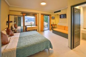 une chambre avec un lit et un canapé dans une pièce dans l'établissement Maria Beach Hotel, à Kíssamos