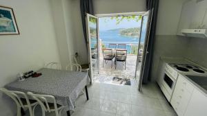 a kitchen with a table and a view of the ocean at Apartments Danijela in Lumbarda