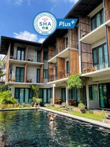 a person swimming in a pool in front of a hotel at Lamphu House Chiang Mai - SHA Extra Plus Certified in Chiang Mai