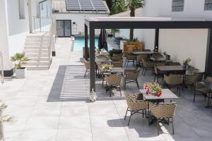 a patio with tables and chairs and a pool at KRACHER Guesthouse No 7 in Illmitz