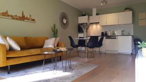 een woonkamer met een bank en stoelen en een keuken bij BnB Antwerpen - CHIQUE in Antwerpen