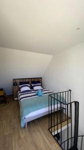 a bedroom with a bed with blue and white pillows at Studio duplex face à la mer in Guidel +16 photos