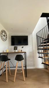 een kamer met een tafel en twee stoelen en een klok bij Studio duplex face à la mer in Guidel